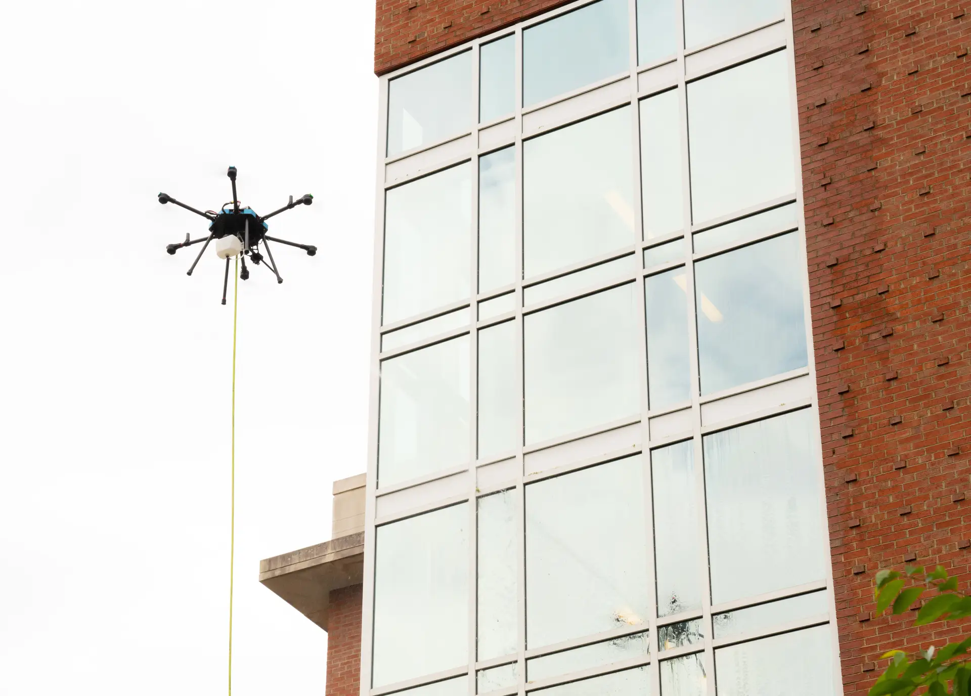 Drone washing services cleaning a government building façade